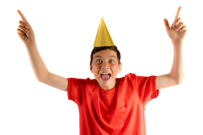 14 year old boy in party hat celebrating