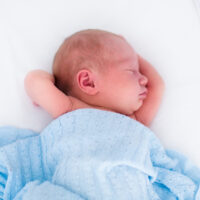 Newborn asleep in bassinet