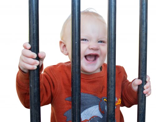 Baby boy behind bars smiling