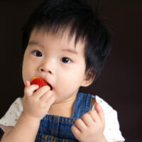 Baby Girl Eating a Strawberry
