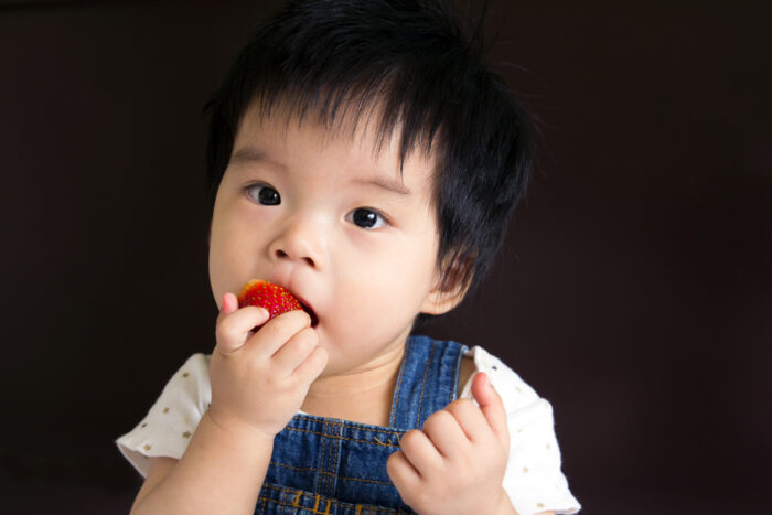 Baby Girl Eating a Strawberry