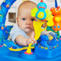 Baby playing with toys in baby bouncer