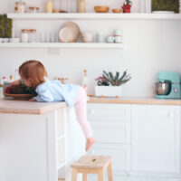 Toddler climbing on step stool