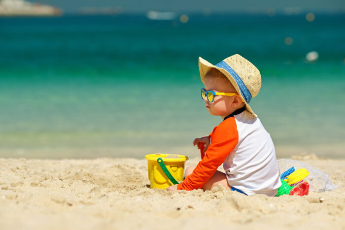 Baby on the beach in his sun hate