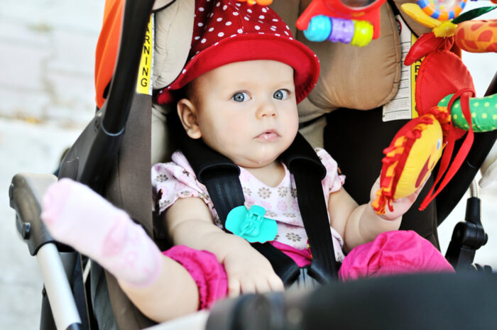 Baby chilling out in stroller with toys