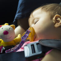 Baby girl safely asleep in car seat