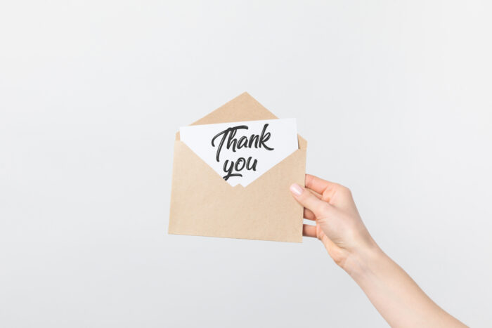 closeup of a woman's hand holding a thank you card