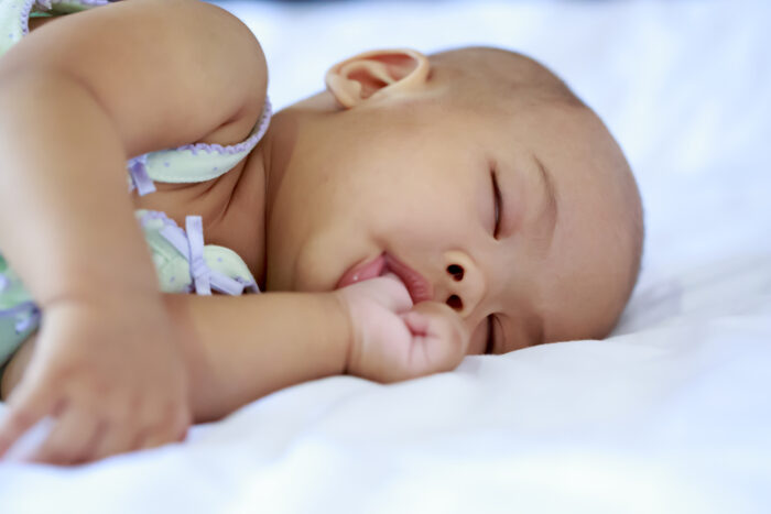 Baby girl sucking her thumb while asleep