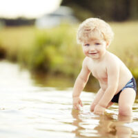 toddler in shallow water outside