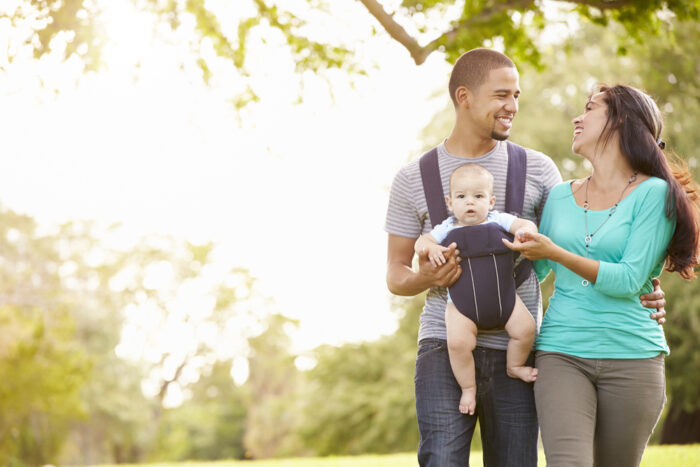 parents walking while dad wears baby in baby carrier