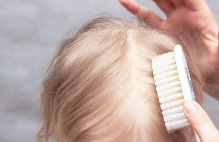 brushing top of baby's hair with brush