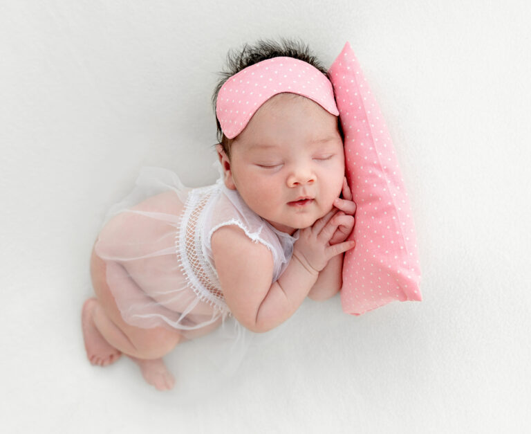 baby girl laying on pillow