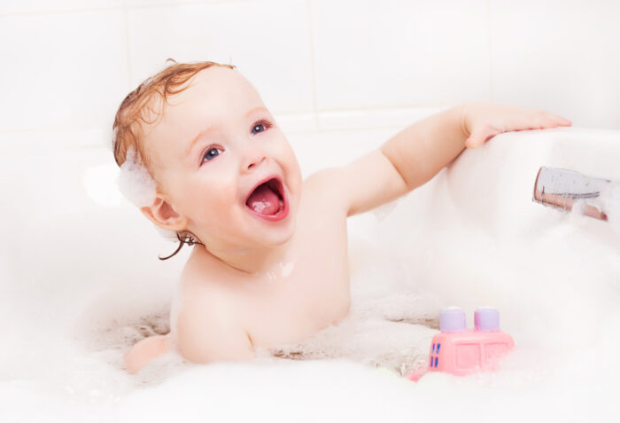 toddler playing in a bubble bath