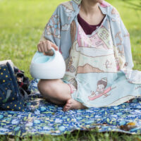 woman sitting outside pumping with breast pump bag