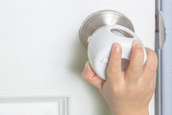 child trying to turn door knob with cover on it