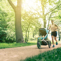 woman jogging with stroller in a park