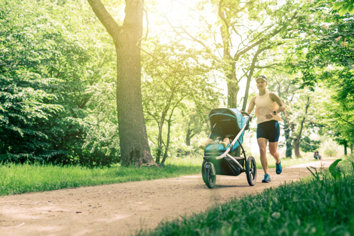 woman jogging with stroller in a park