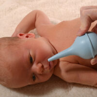 baby with nasal aspirator