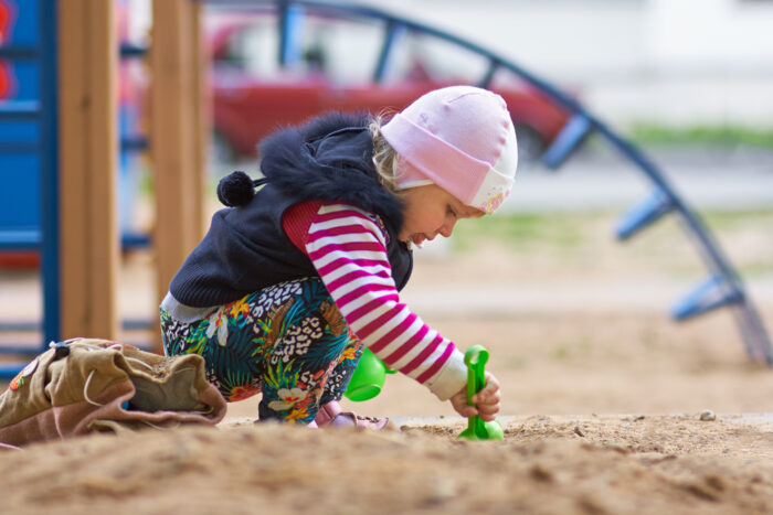 toddler playing with toy outside at a playground