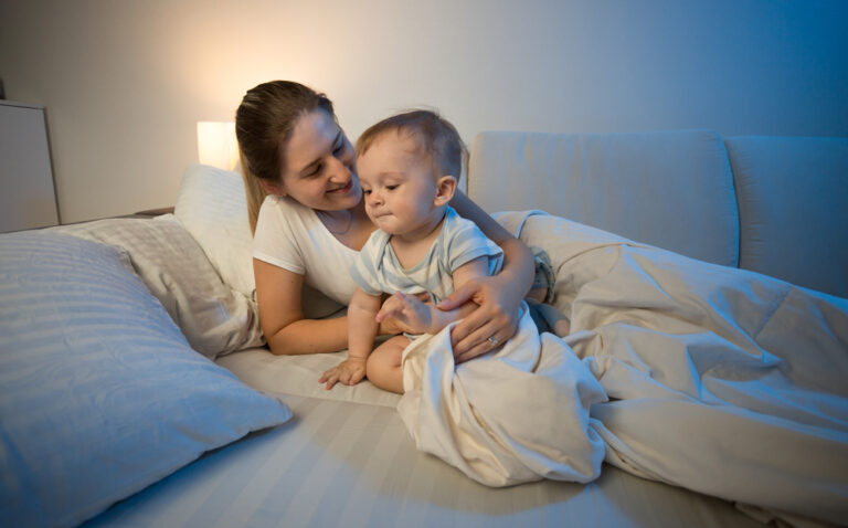 mom and baby sitting in bed at night