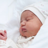 baby sleeping on white sheets