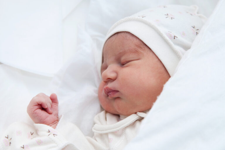 baby sleeping on white sheets