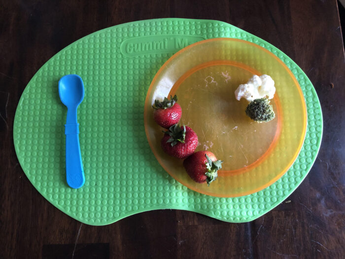 toddler placemat with plate and spoon on it