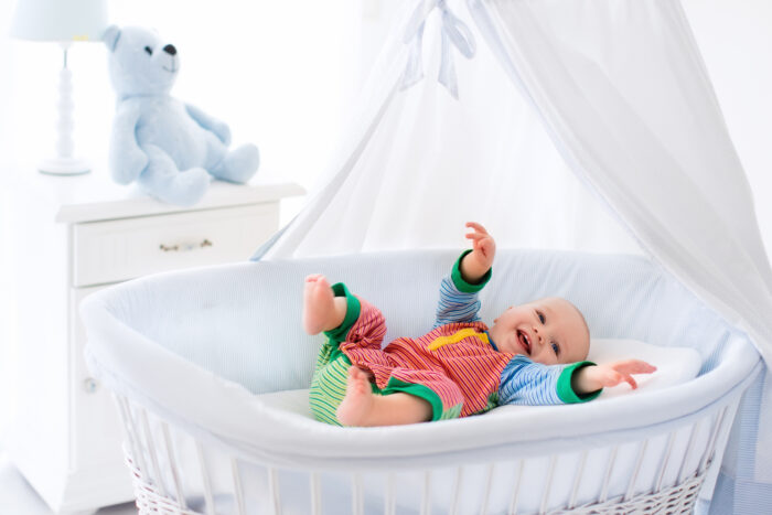 baby laying in a white bassinet