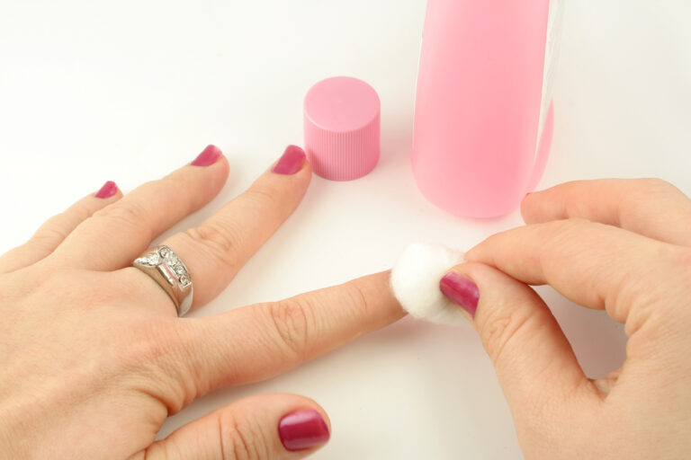 woman taking nail polish off her nails