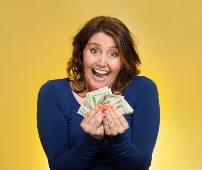portrait of an excited mom holding lots of cash