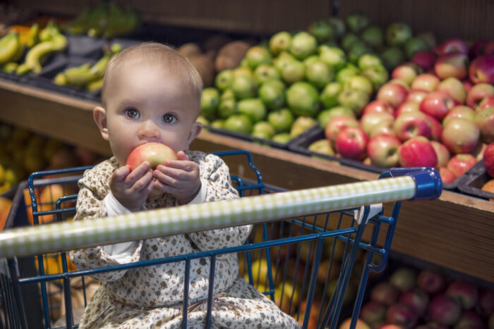 baby sitting in shopping cart