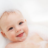 cute baby in bath with soap for baby