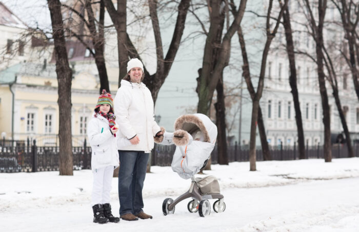 family outside in the snow with stroller