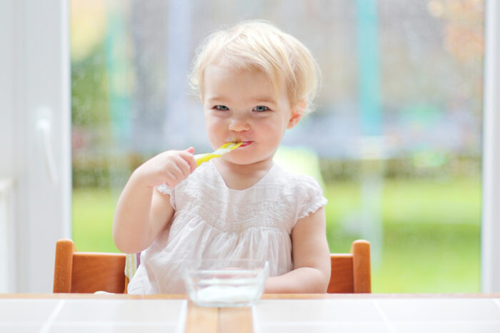 baby eating yogurt at the table