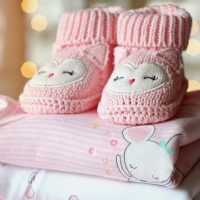 Image of pink baby booties on baby blankets