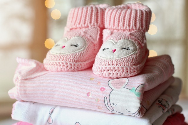 Image of pink baby booties on baby blankets