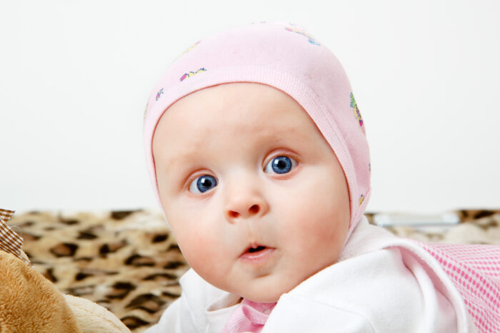 Close up of baby girl in pink laying on cheetah rug