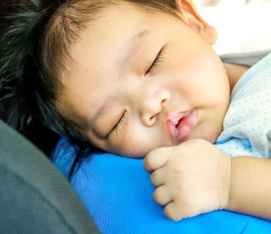 Close up of baby asleep on blue pad