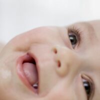 Close up of brown eyed baby smiling