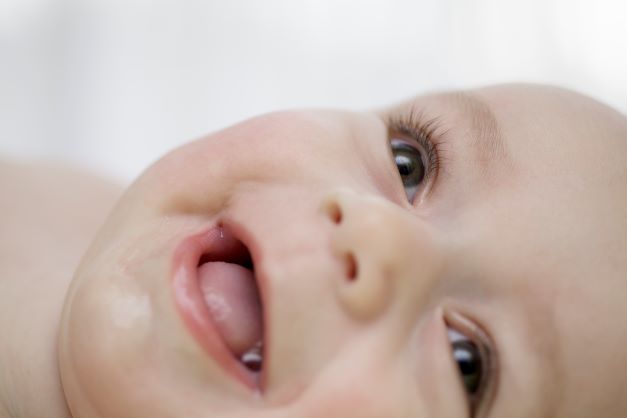 Close up of brown eyed baby smiling