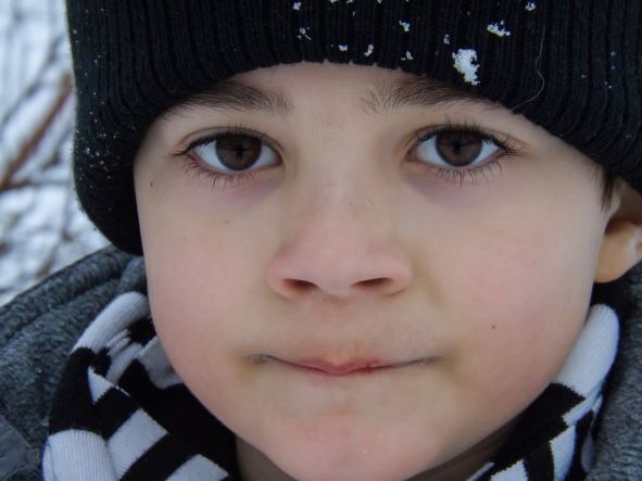 Close up of brown eyed boy in snow hat