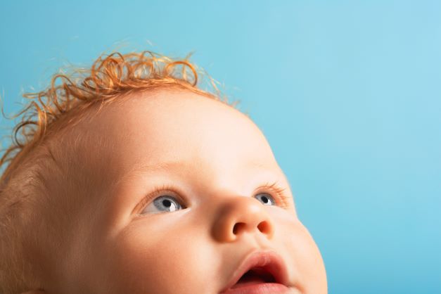 Close up of red headed baby looking up