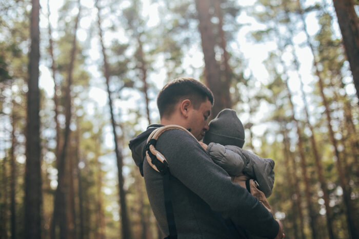 Dad Hiking with Baby in Car Carrier in Woods