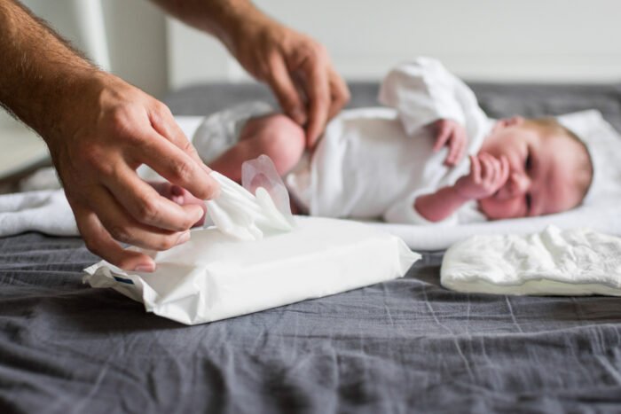 Father Wiping Newborn With Baby Wipes