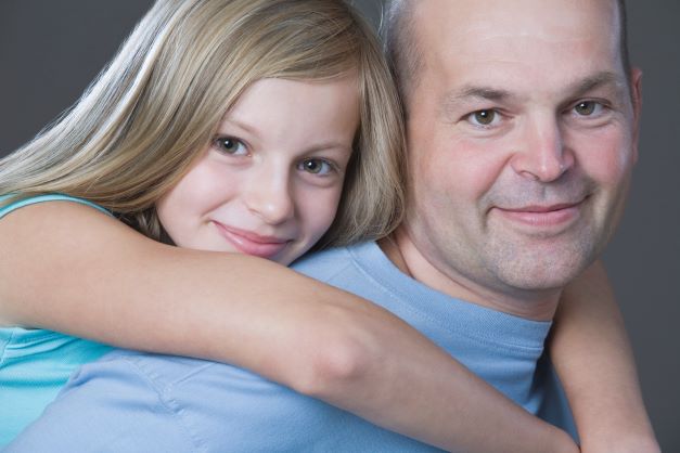 Daughter hugging dad from behind