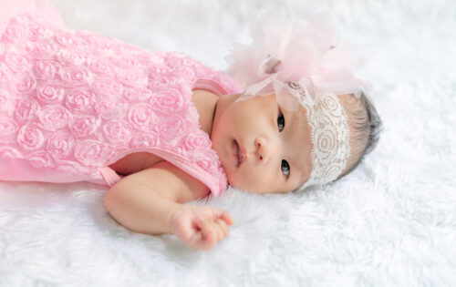 Closeup cute asian baby girl wearing Flower headband on white wool carpets,baby fashion concept