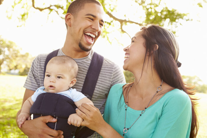 Parents laughing with baby in carrier