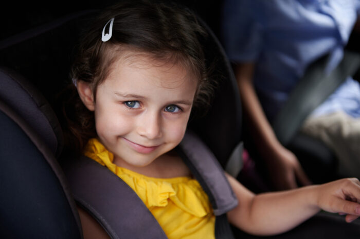 Smiling Girl Belted in Booster Seat