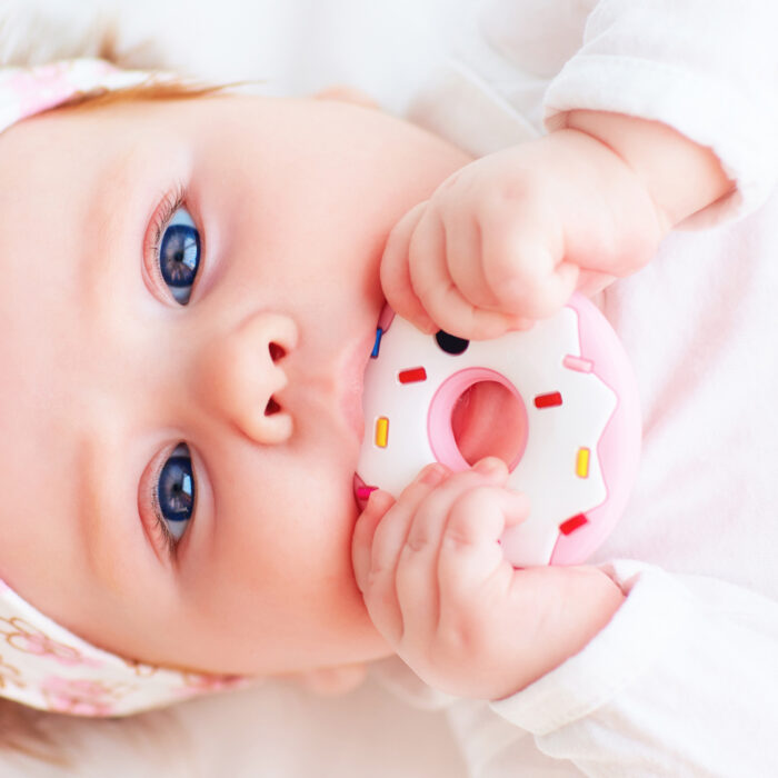baby chewing on a donut teething toy