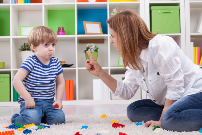 angry mother disciplining a disobedient toddler without yelling at him